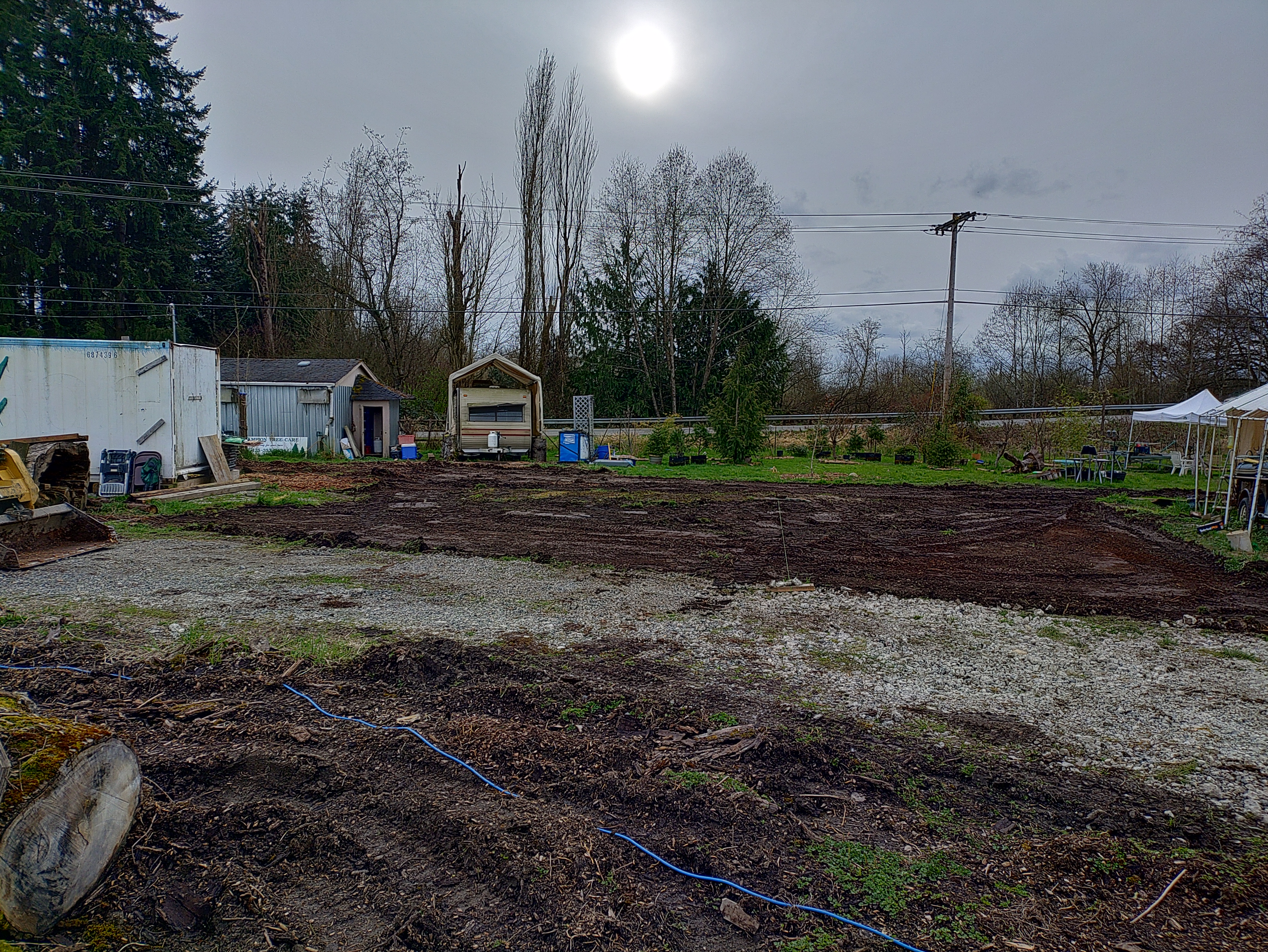 An illustration of a man operating an excavator, cutting a trench in his yard in front of a suburban home.