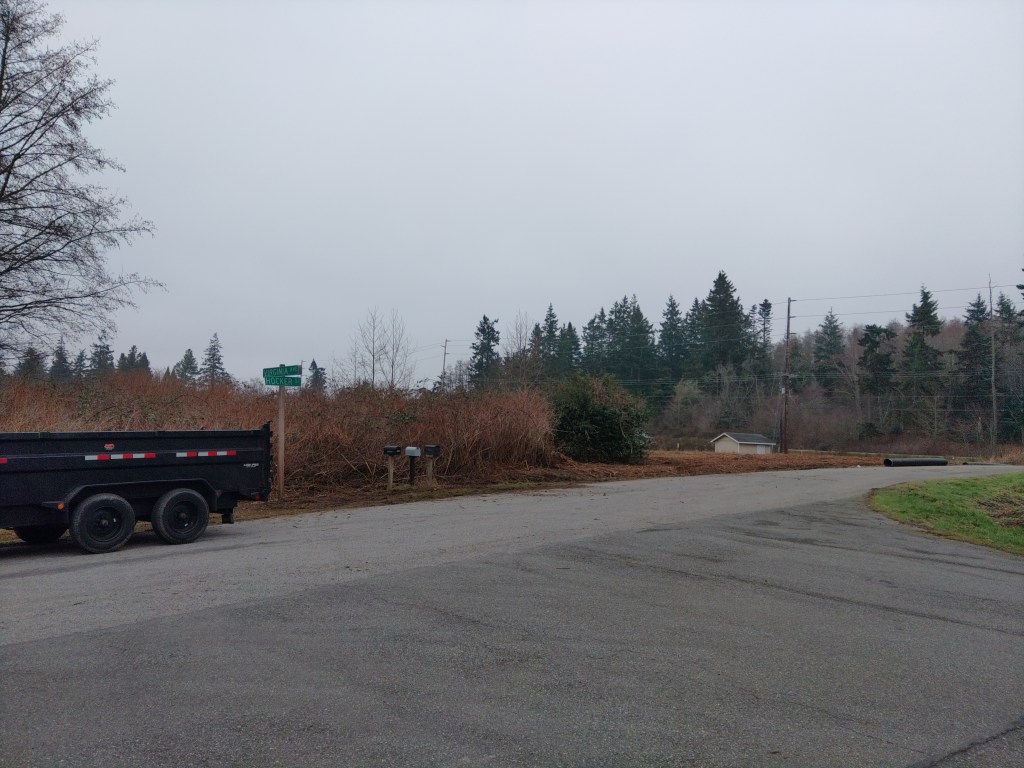 An illustration of a man operating an excavator, cutting a trench in his yard in front of a suburban home.