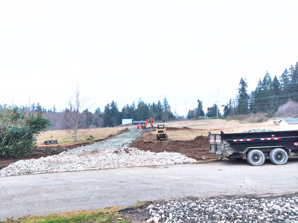 An illustration of a man operating an excavator, cutting a trench in his yard in front of a suburban home.