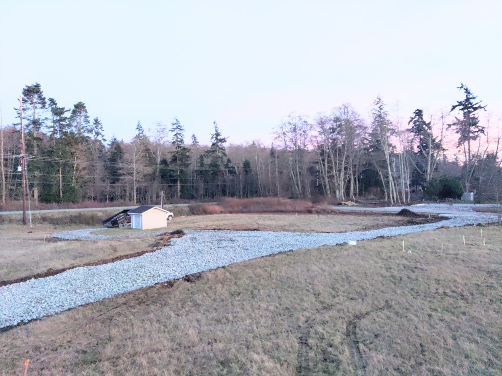 An illustration of a man operating an excavator, cutting a trench in his yard in front of a suburban home.